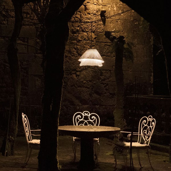 Outdoor Pendants: Exterior LED pendant light suspended over a bistro table & chairs in a courtyard at night