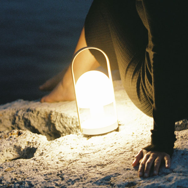 Outdoor Portable & Cordless Lamps: Portable & cordless LED lamp on a rocky beach next to a woman at night, with a sea view