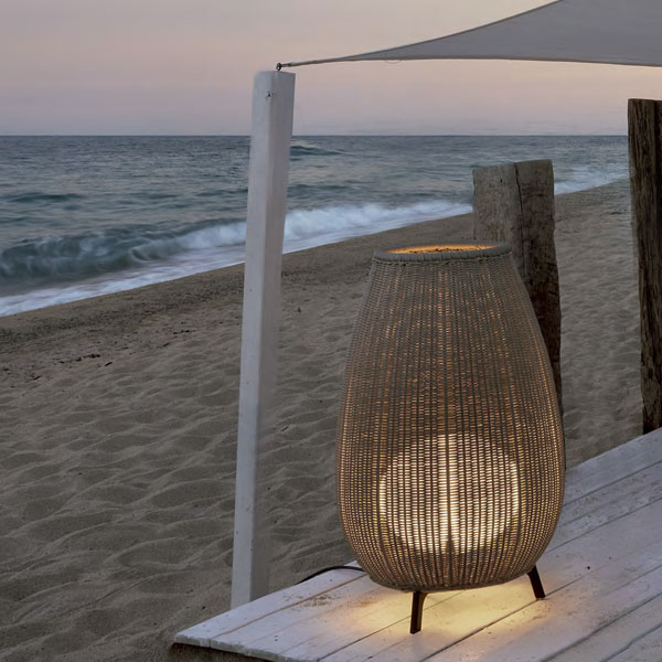 Outdoor Table & Floor Lamps: Exterior table & floor LED lamp lighting a wooden platform on the beach overlooking the sea at dusk
