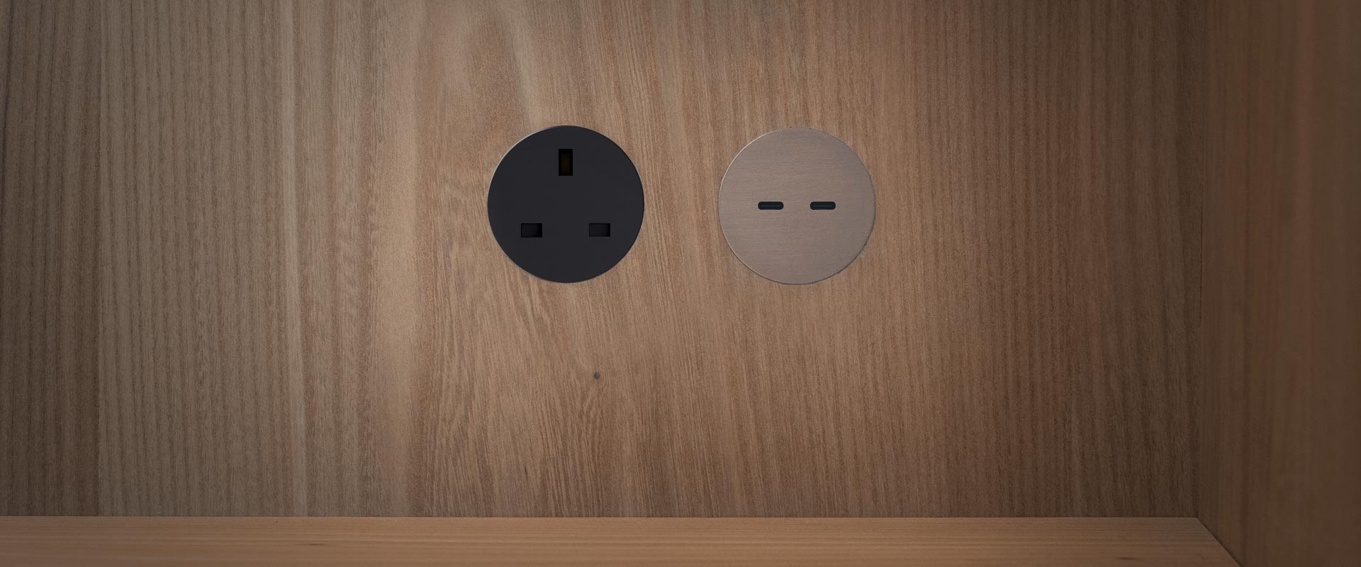 Rond round switchless UK power socket in matt black & bronze USB socket installed into a wooden cupboard