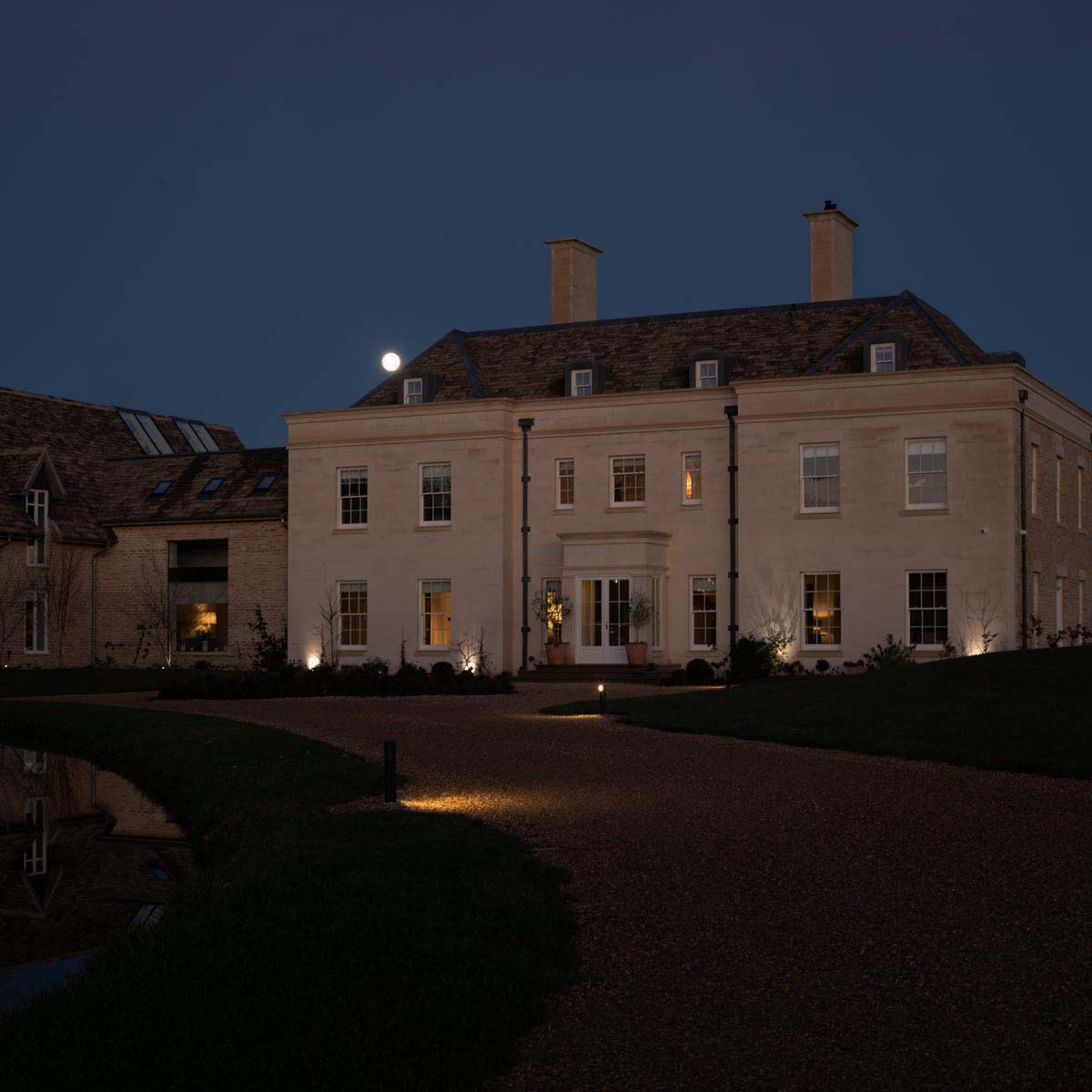 Lighting Design Oxfordshire outdoor shot of the grand front of the house at night, spotlights & pathlights