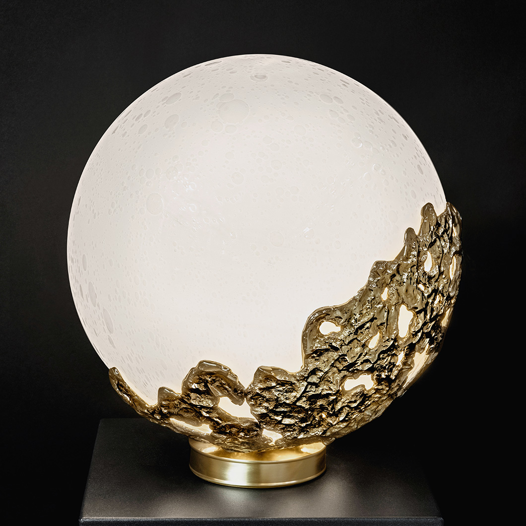 Full view of the Esperia Natalia Table Lamp, resembling the surface of the moon in its white globe lampshade