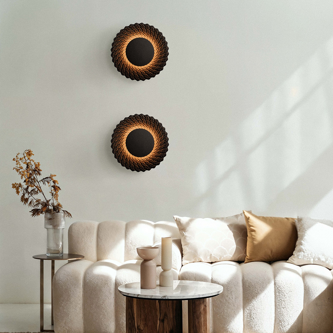 Round lamp made from black quartz sand emitting a warm glow alternative image